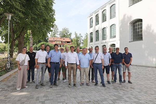 Eine Gruppe Menschen vor der Neuen Spinnerei im ERBA-Gelände.