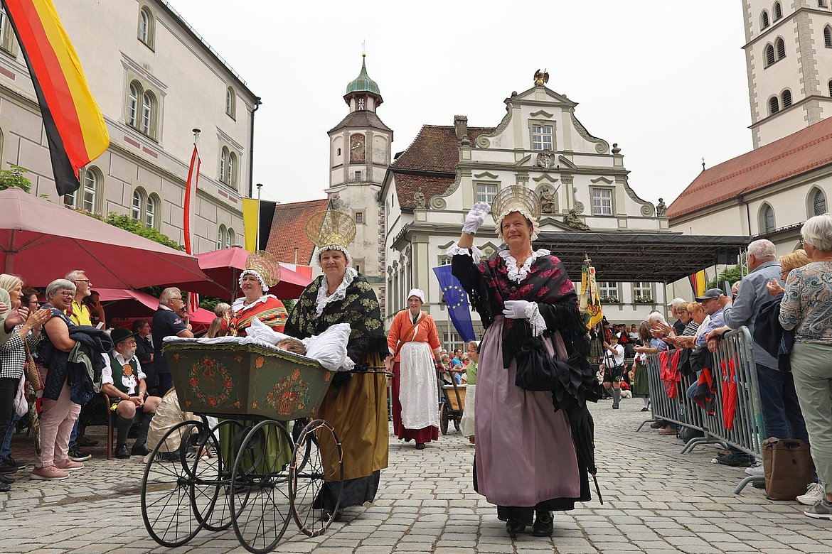 Menschen in Trachten im Umzug vor dem Rathaus