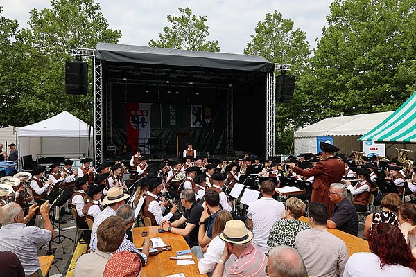 Menschen hören der Stadtkapelle Wangen zu.