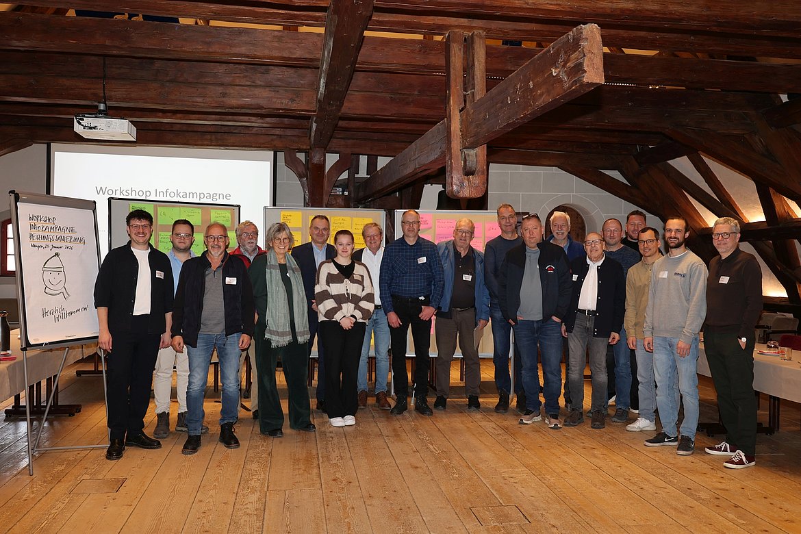 Eine Gruppe Menschen vor den Arbeitsergebnissen eines Workshops.
