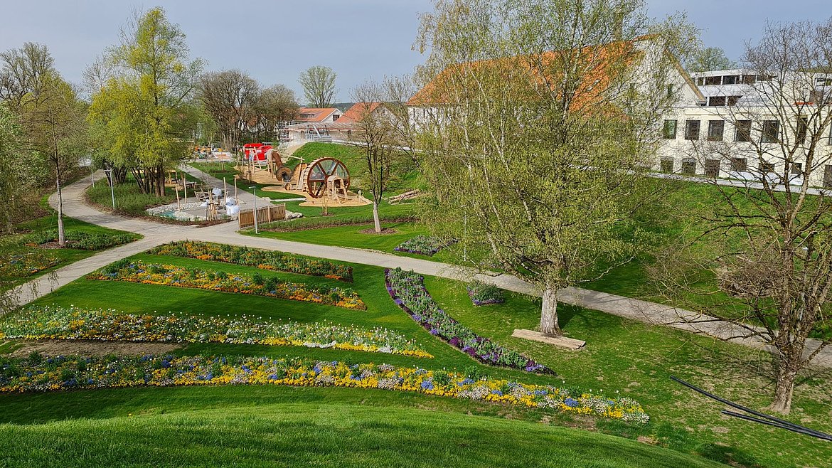 Foto von einem Aussichtspunkt in den Park mit Blumen, dem Energiespielplatz und der ERBA