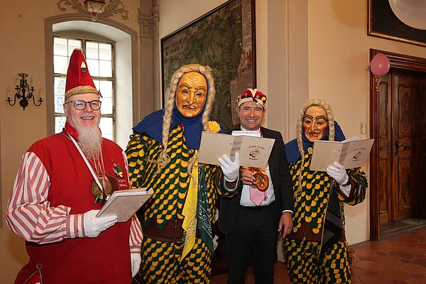 Drei Narren und OB Lang mit Narrenkappe.