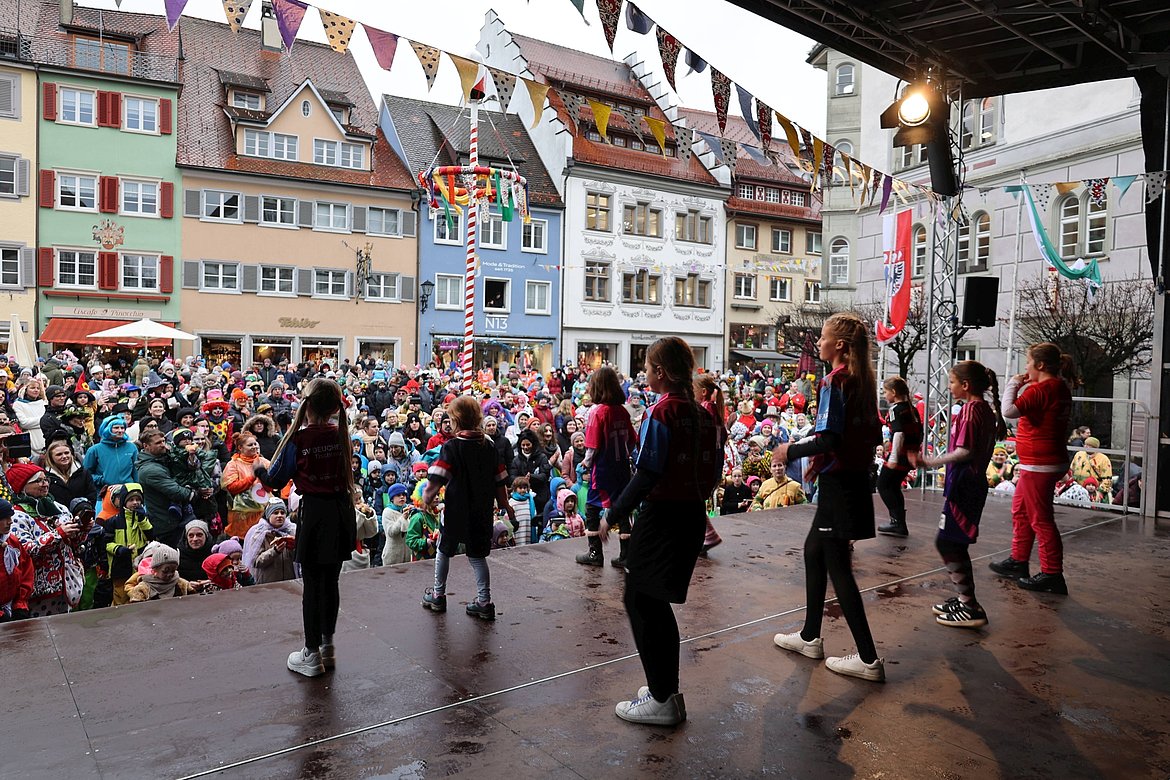 Kindertanzgruppe auf der Bühne vor dem vollen Marktplatz.