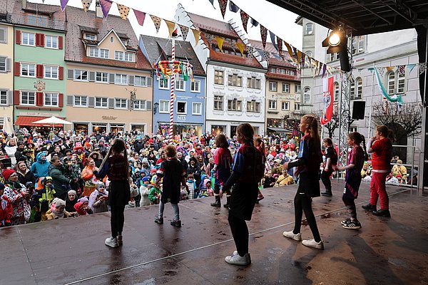 Kindertanzgruppe auf der Bühne vor dem vollen Marktplatz.