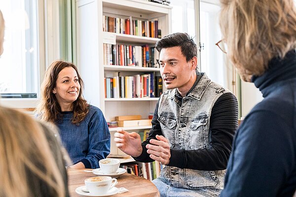 Ein Mann und drei Frauen erzählen einander.
