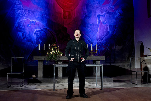 Eine Person steht vor einem Altar.
