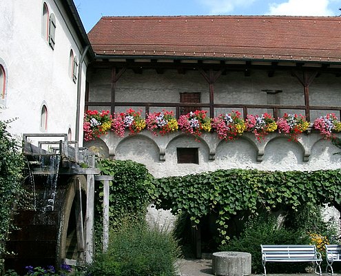 Blick auf den Wehrgang mit vielen Blumenkästen.