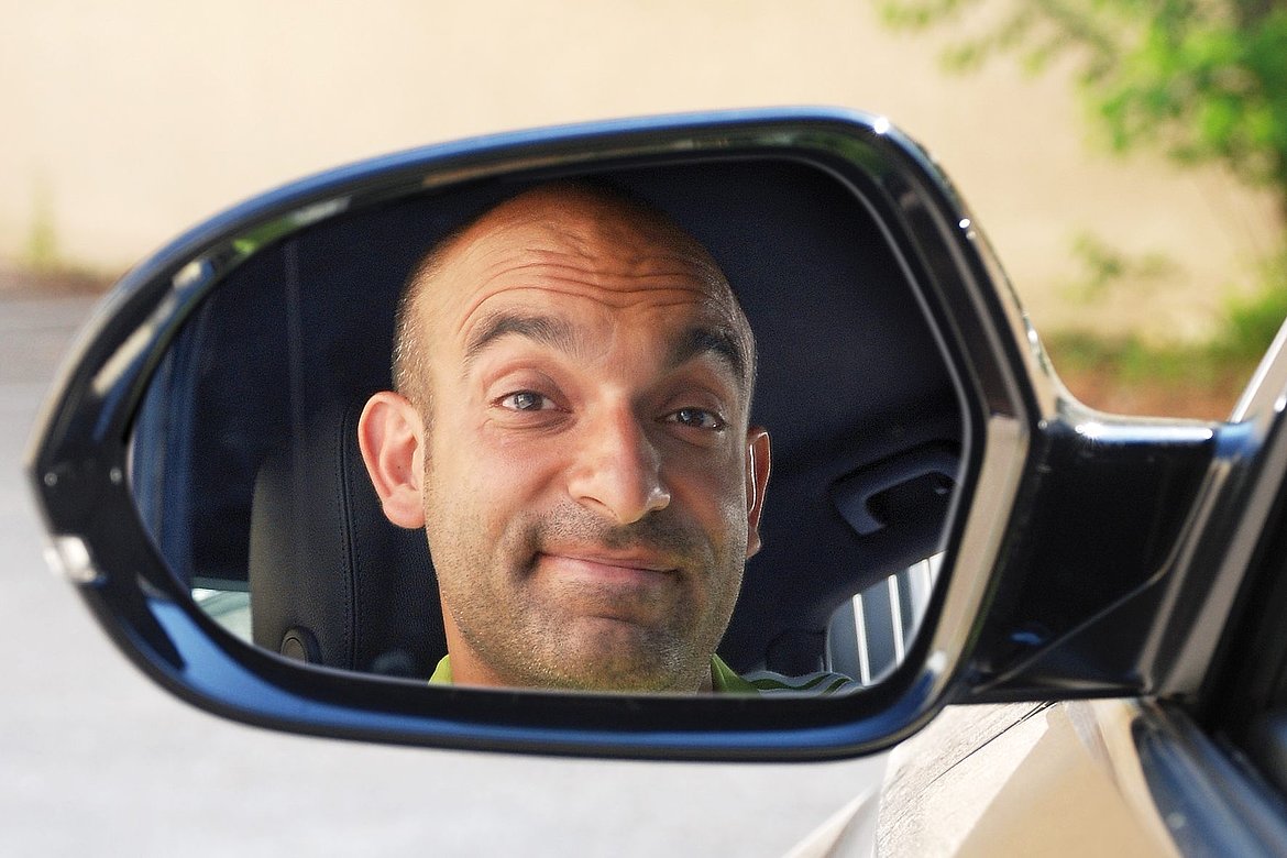 Ein Mann ist im Rückspiegel seines Autos zu sehen