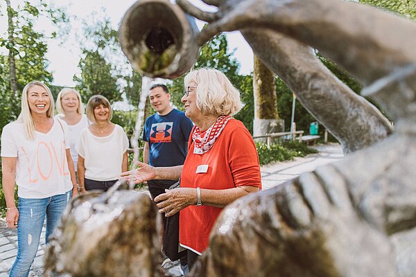 Menschen bei einer Führung am Kopfwäschebrunnen.