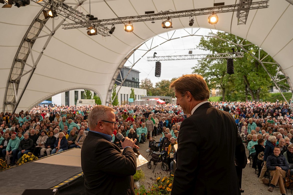 Ein Mann interviewt OB Michael Lang auf der großen Bühne vor vielen Menschen
