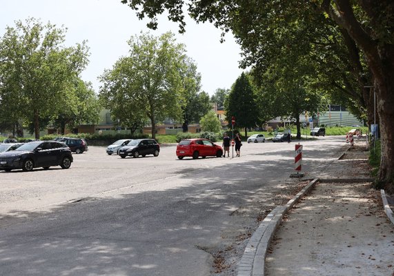 Parkplatz bei den Sporthallen, Straße und Gehweg.