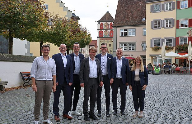 Mehrere Personen stehen auf dem Marktplatz mit dem Rücken zum Martinstor