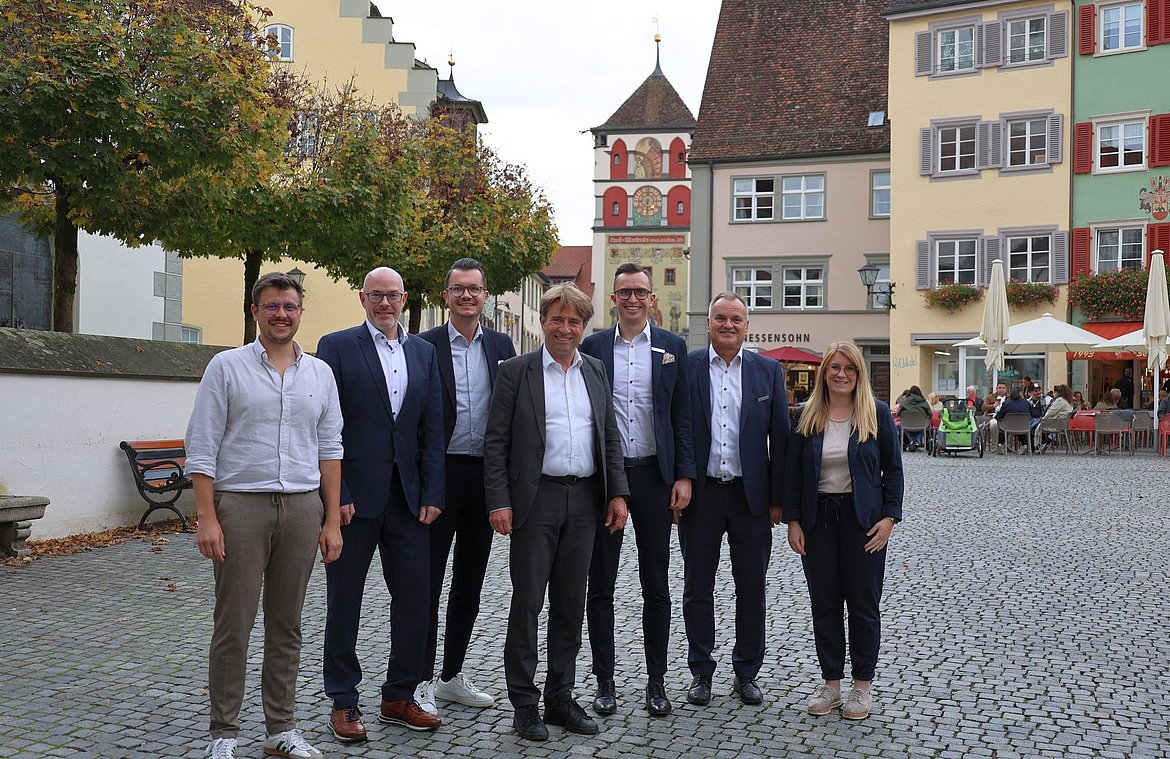 Mehrere Personen stehen auf dem Marktplatz mit dem Rücken zum Martinstor