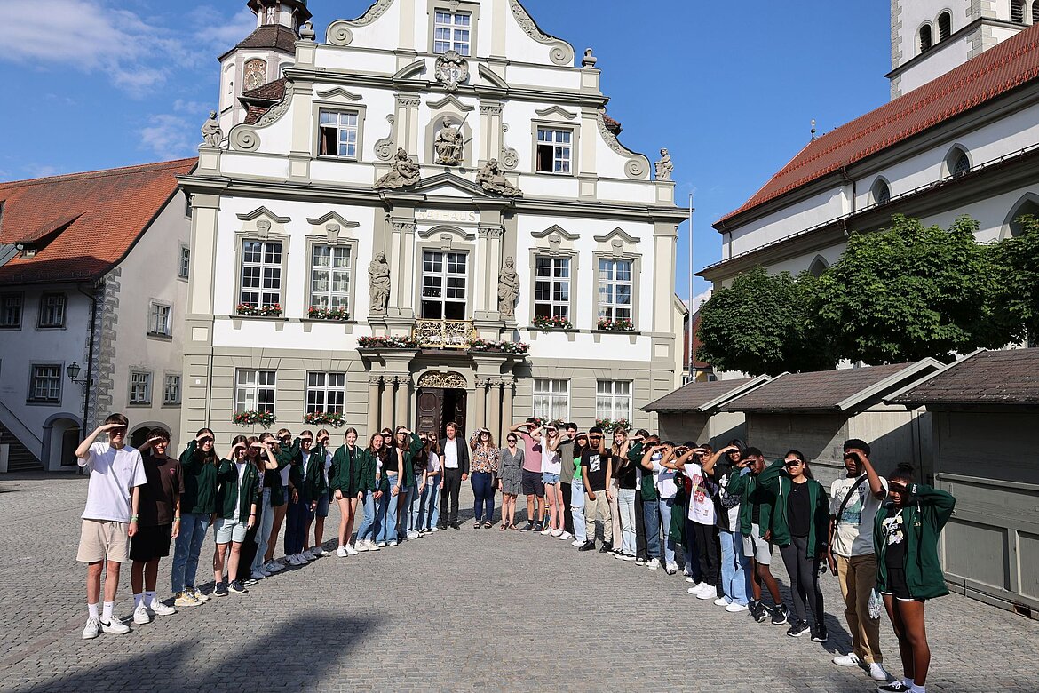 Schülerinnen und Schüler bilden mit Lehrerinnen und Lehrern und OB Lang vor dem Rathaus ein V.