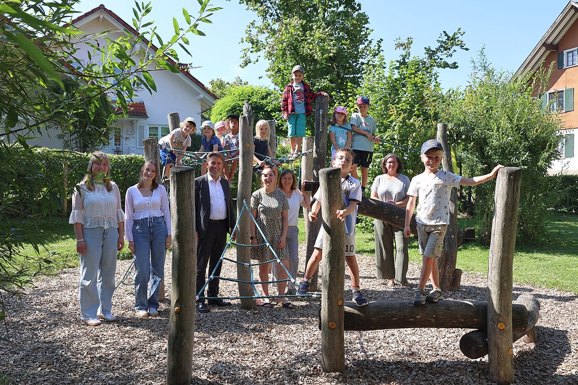 Erwachsene und Kinder an einem Klettergerät im Garten