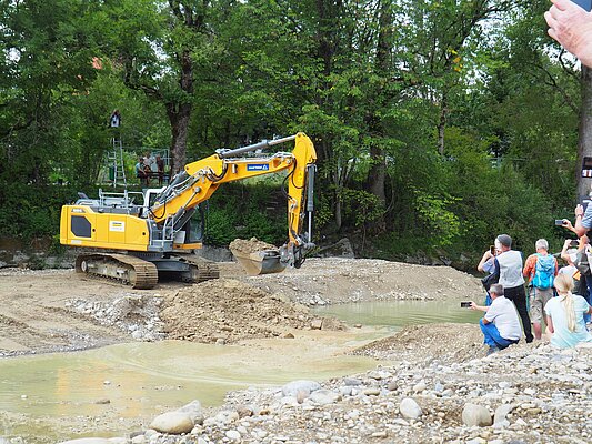 Bagger baggert im Flussbett