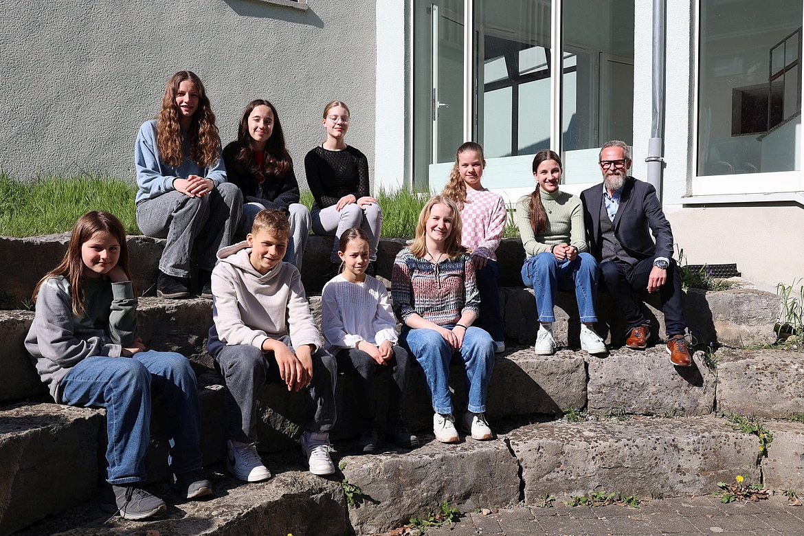 Eine Gruppe junger Menschen und der Schulleiter
