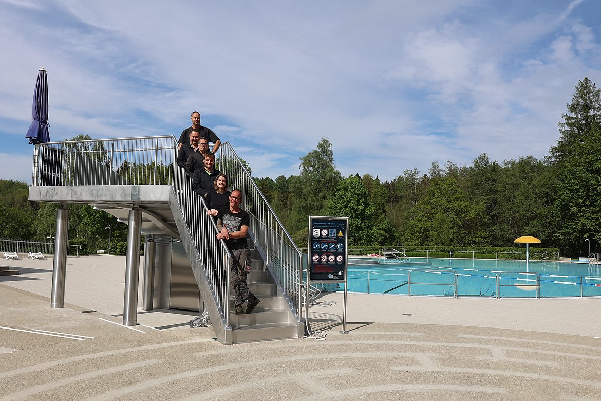 Das  Freibad-Team steht auf der Treppe zur Breitwellenrutsche.