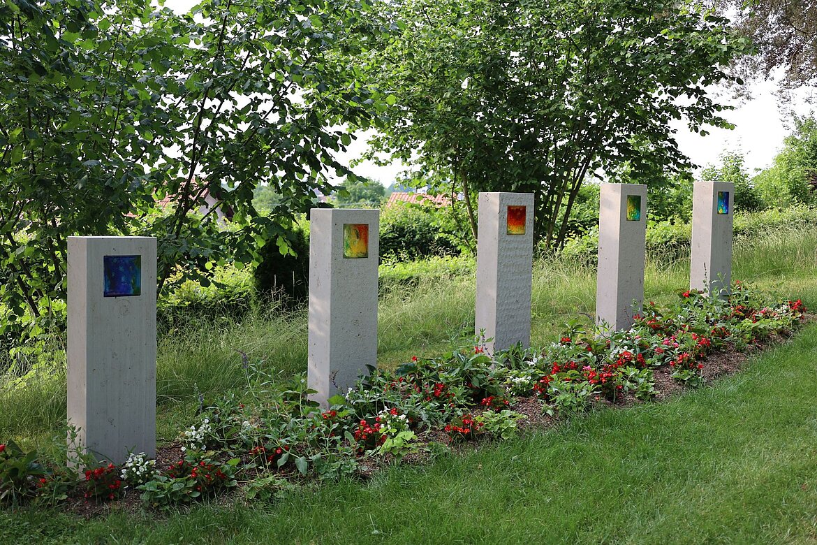 Stelen mit Bildern auf dem Friedhof