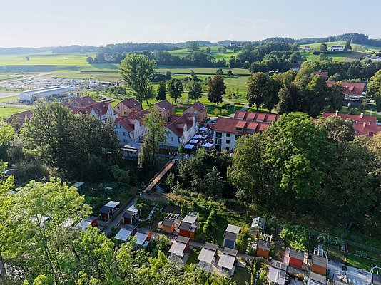 Blick von oben auf die ehemalige Arbeitersiedlung, die Brücke über den Kanal und die Werksgärten.