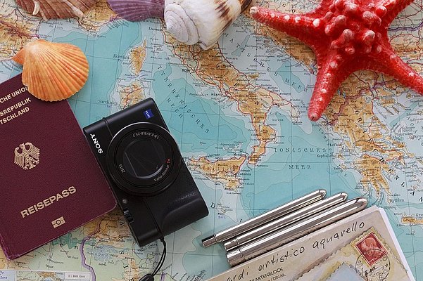 Landkarte mit Ausweis, Fotoapparat und Muscheln