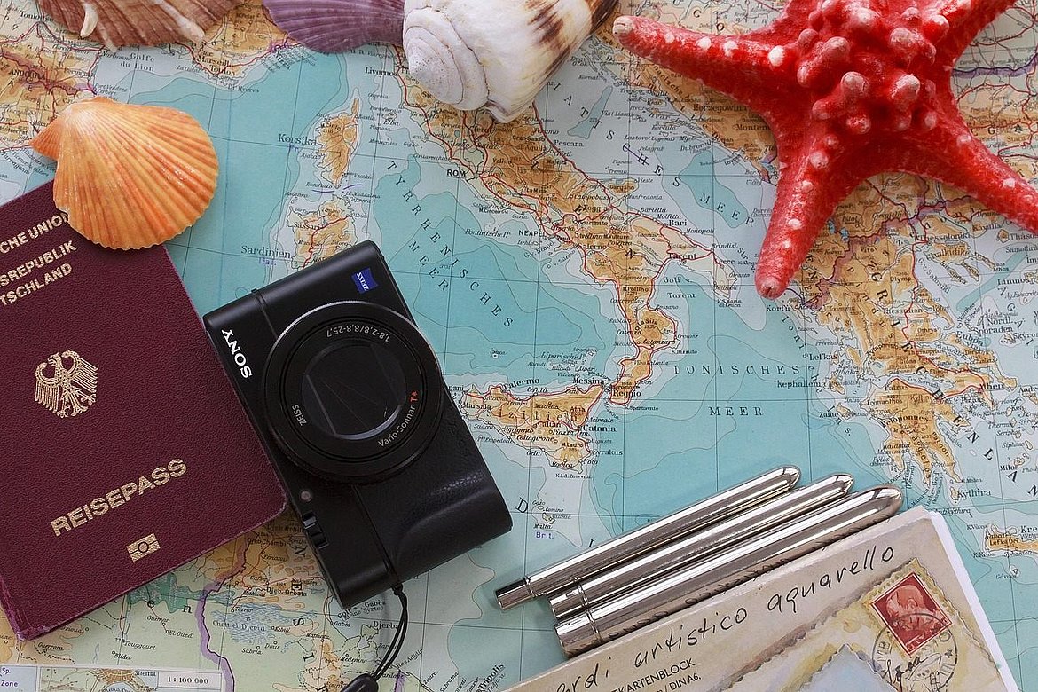 Landkarte mit Ausweis, Fotoapparat und Muscheln