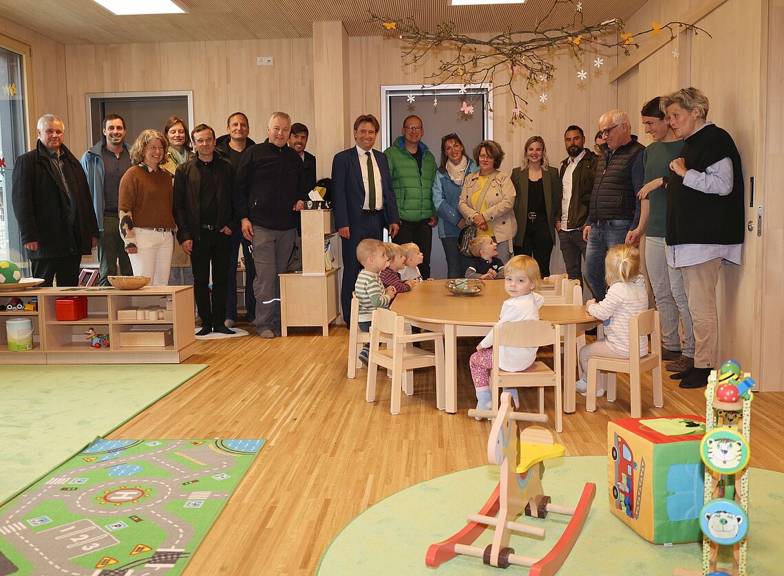 Erwachsene und Kinder freuen sich über den neuen Raum aus Holz