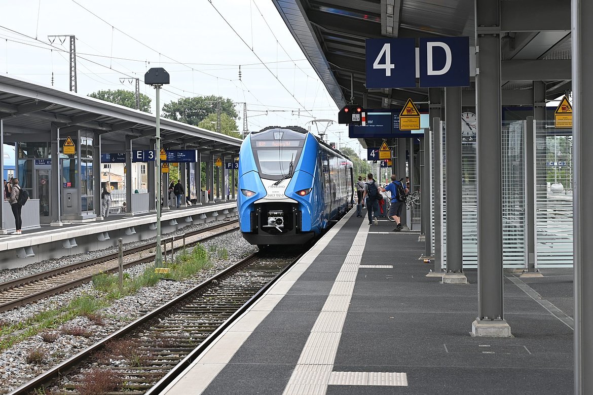 Blauer Zug an einem Bahnhof