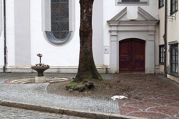 Ist-Zustand am Spatzenbrunnen. Der Brunnen ist leer. Die Pflastersteine sind sehr verschieden hoch. 