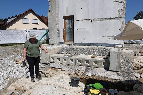 Eine Frau deutet auf die Steine beim Turm. 