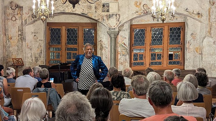 Schauspieler mit glänzender blauer Jacke im Weberzunftsaal