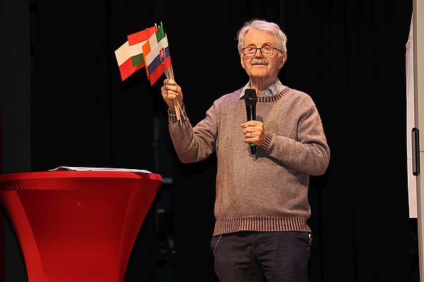 Ein Mann mit Fähnchen europäischer Länder in der Hand