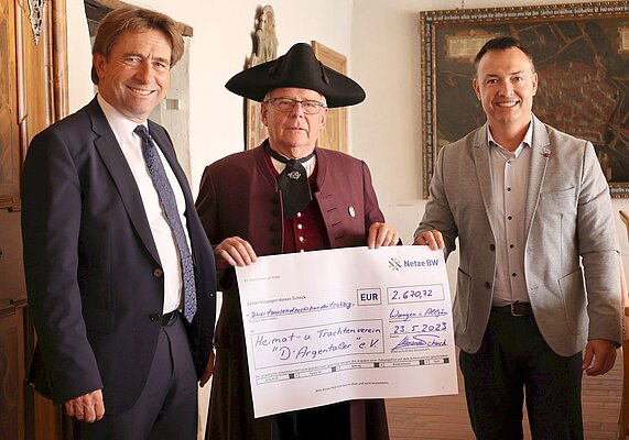 Drei Männer und ein symbolischer Scheck 