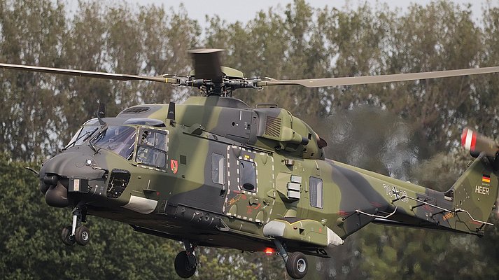 Ein Hubschrauber der Bundeswehr landet hinter Bäumen