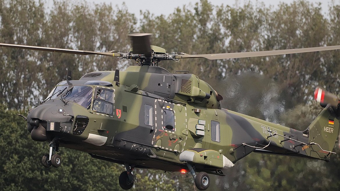 Ein Hubschrauber der Bundeswehr landet hinter Bäumen