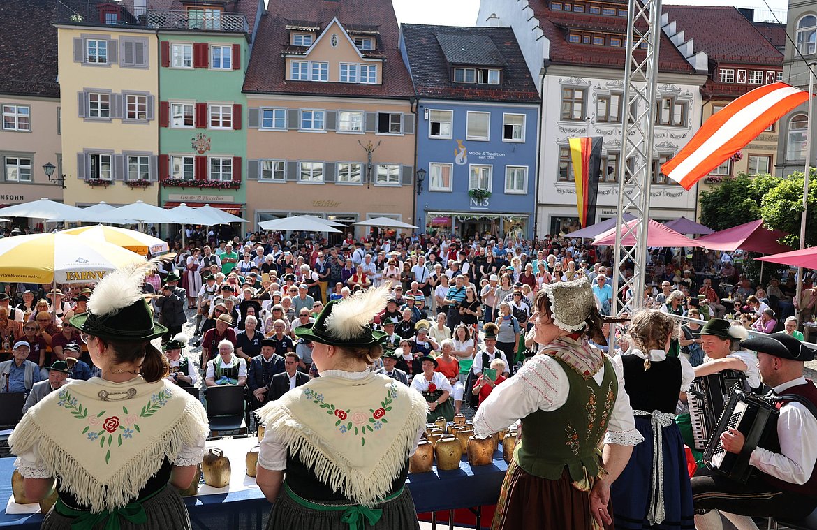Blick von der Bühne mit Trachtenträgern auf den vollbesetzten Marktplatz