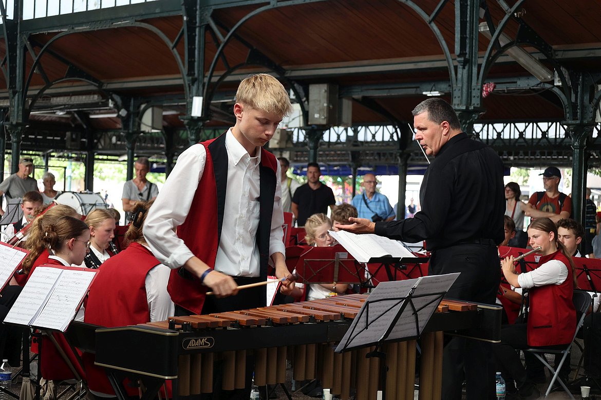 Ein junger Mann an einem Musikinstrument vor der Musikkapelle