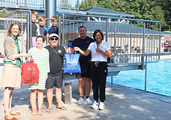Mitarbeiter von Stadt und Freibad beschenken eine Familie.