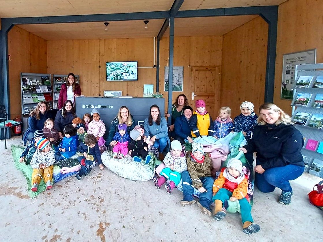 Kindergartenkinder sitzen auf bunten Säcken im Pavillon der Themengärten in der Landesgartenschau