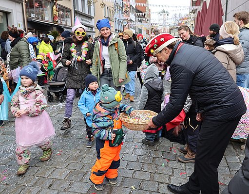 OB Lang bietet Kindern Süßigkeiten an