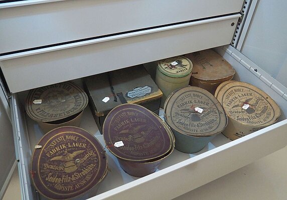 Offene Schublade im Museumsdepot mit Hutschachteln