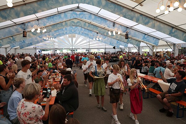 Einmarsch durch Bläser, OB Lang, Kinderfestkommission im vollen Festzelt