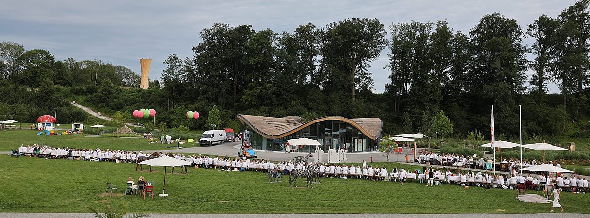 Lange weiße Tafel auf der Argenwiese mit sehr vielen Menschen beim Essen