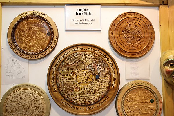 Schützenscheiben aus Holz mit Schrift und teilweise Zeichnungen.