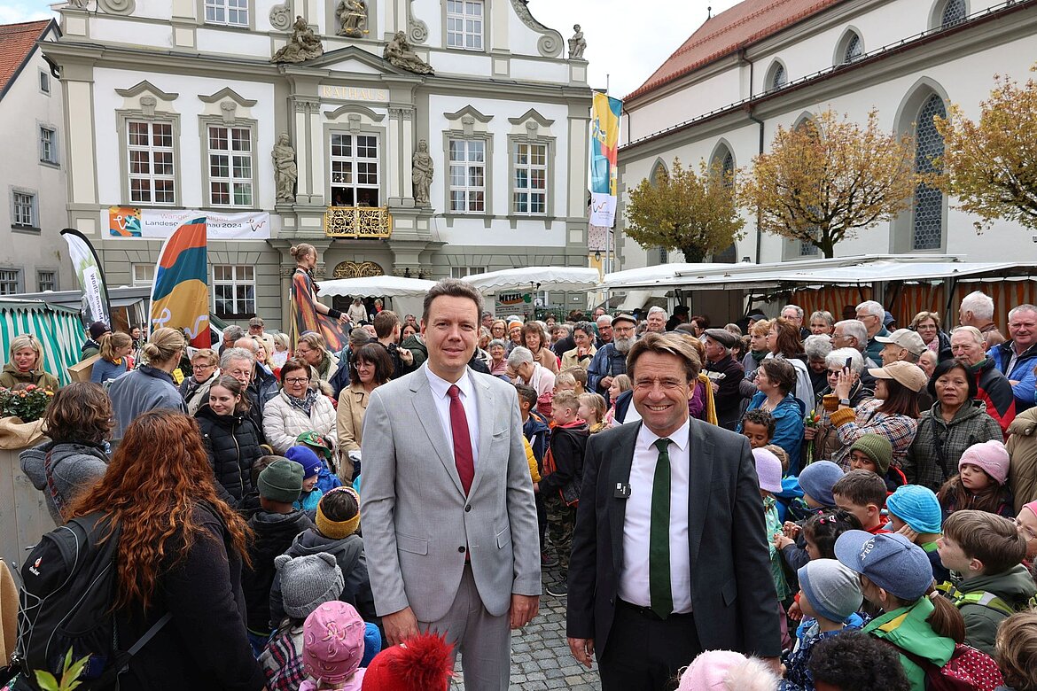 Landrat Harald Sievers und Oberbürgermeister Michael Lang mit vielen anderen Menschen auf dem Marktplatz