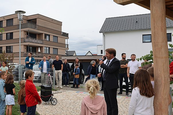 Männer, frauen und Kinder hören OB Michael Lang zu
