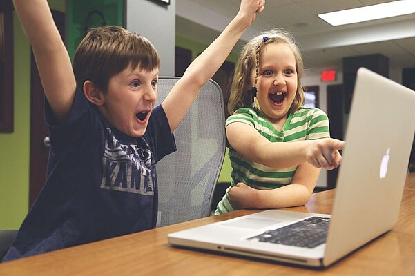 Kinder spielen am Computer.