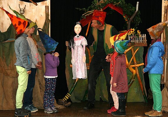 Figur des Schneewittchens und Kinder als Zwerge